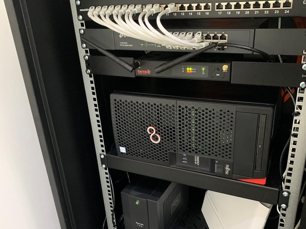 Aufgeräumter Serverschrank mit Patchfeld, Firewall, Switch, Server und USV